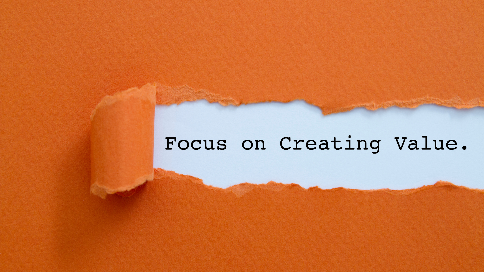 Focus on creating value written under torn orange paper